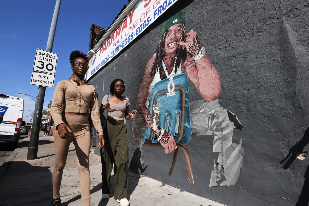 Unas jóvenes caminan junto al mural de King Von en el tristemente célebre «O Block» de S. Martin Luther King Dr., en el South Side de Chicago. King Von fue un rapero y miembro de la banda Black Disciples asesinado a tiros en 2020.